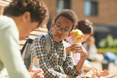 Teenage boy eating a snack during school recess