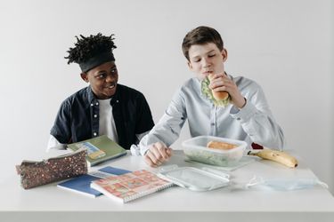 Boy eating a sandwich from a lunchbox